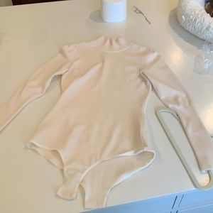 Alaia Cream long sleeve turtleneck bodysuit.